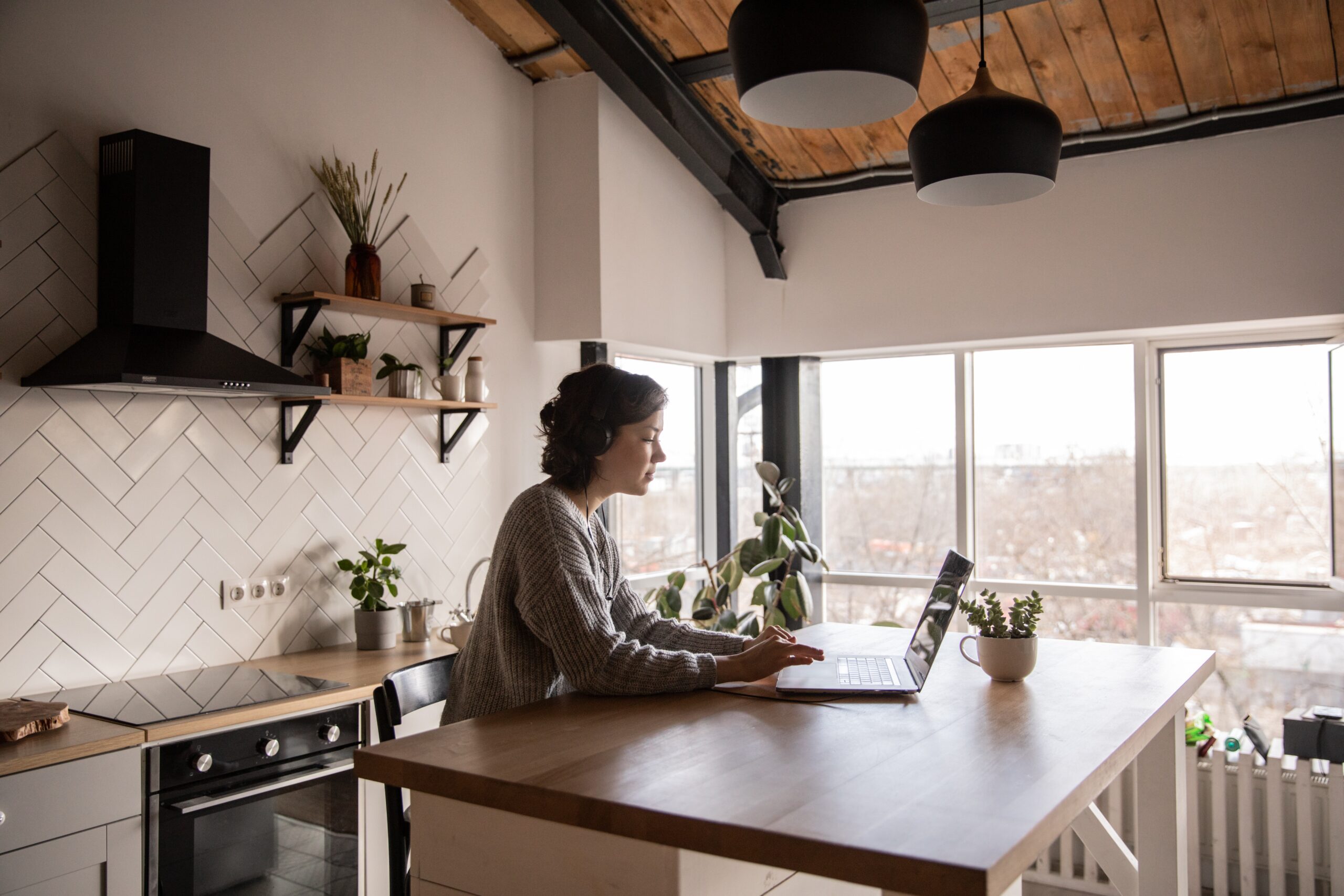 Woman typing on laptop in kitchen