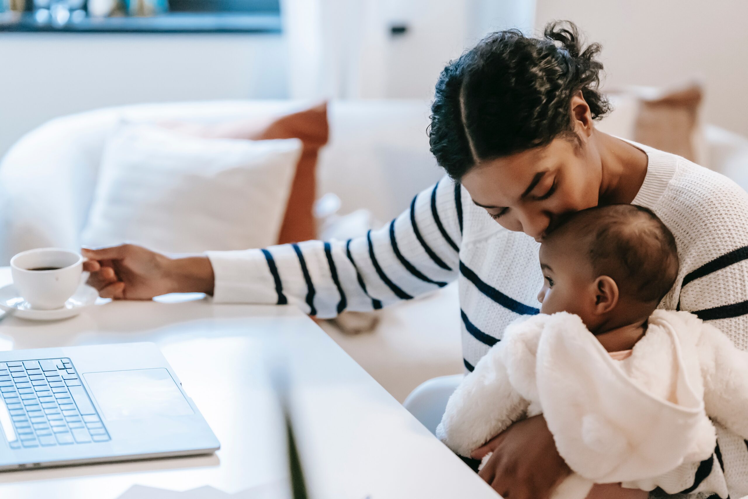 mother kissing child sitting at desk