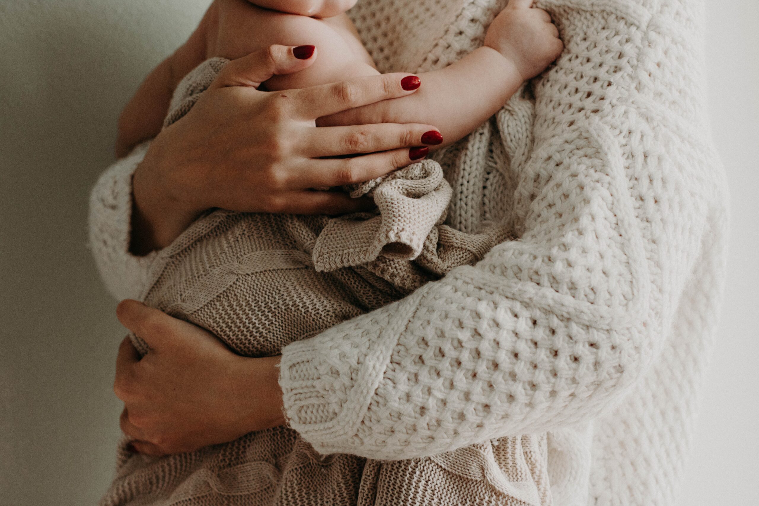 closeup of a baby in the arms of a woman