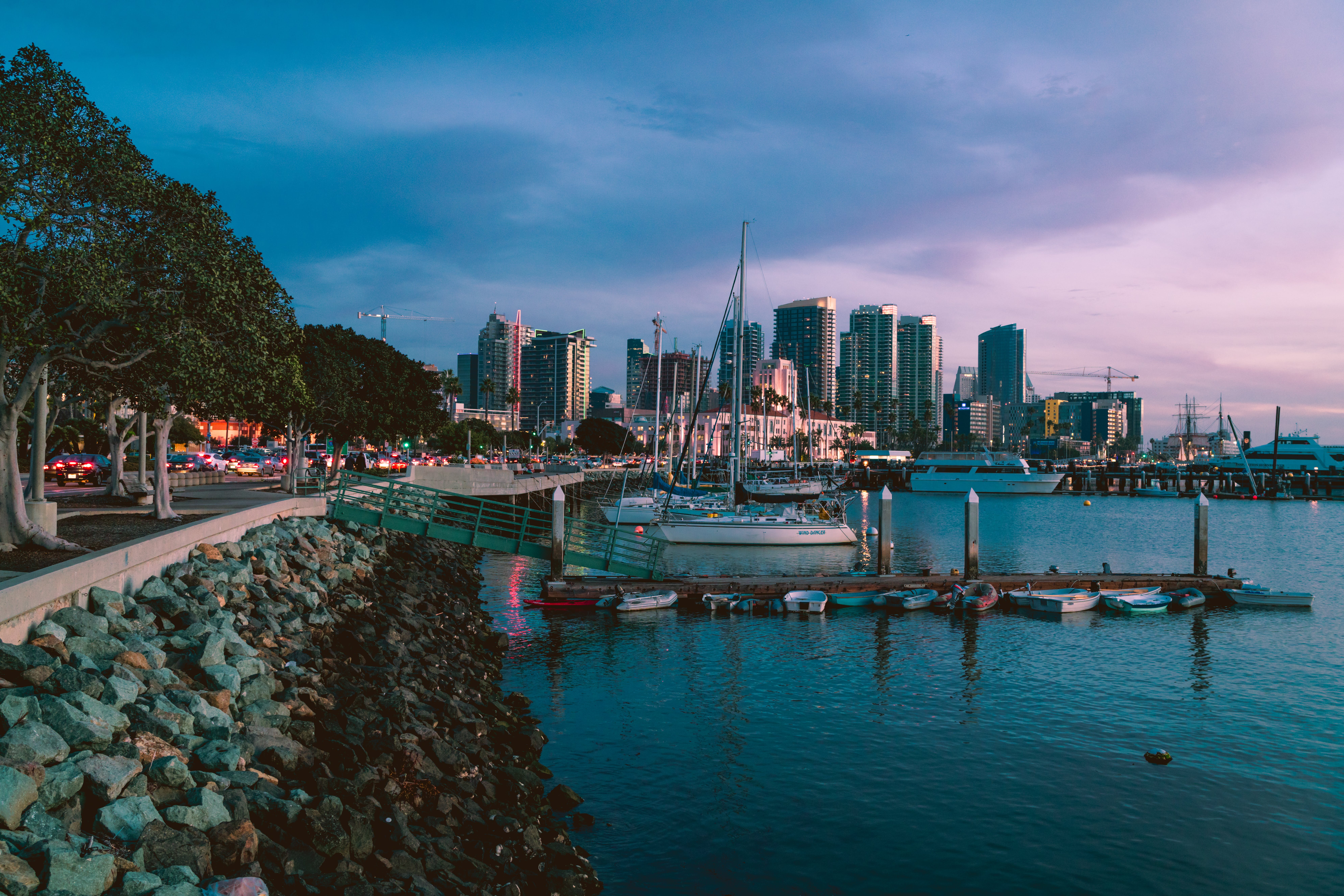 ships in a marina in front of san diego buildings at night